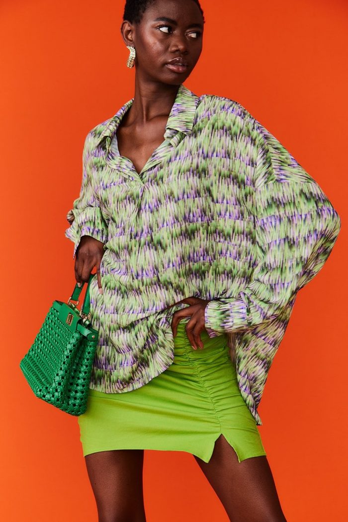 Female model wearing Jayley's Silk Blend Digital Print Blouse with a green skirt and handbag