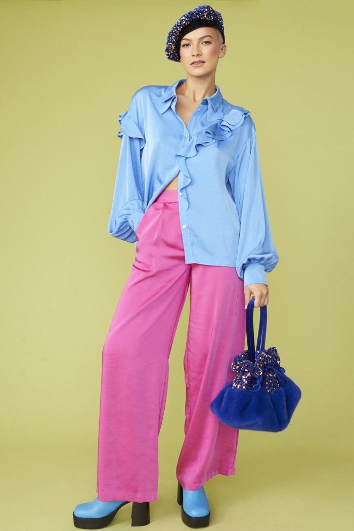 Woman wearing a beret, light blue blouse and pink trousers