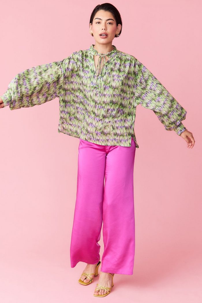 Woman wearing pink trousers and green blouse