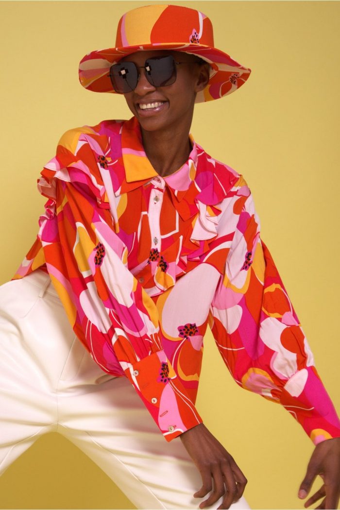 Woman wearing a patterned hat and matching top with sunglasses