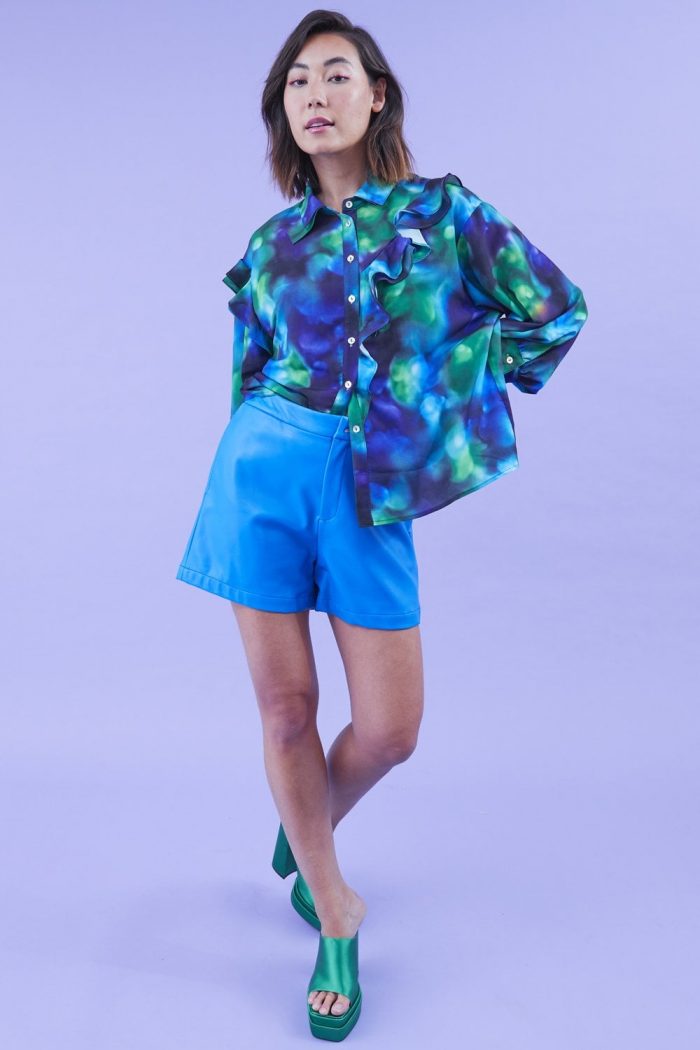 Woman wearing blue blouse and blue shorts 