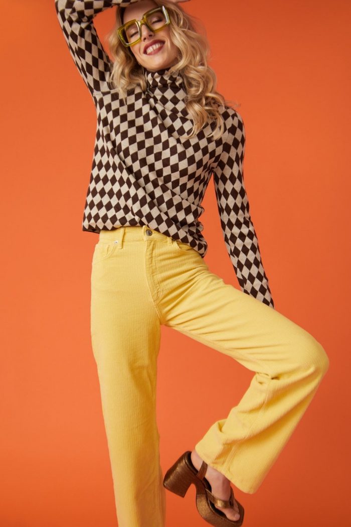 Woman wearing yellow banana peel trousers and a checked top